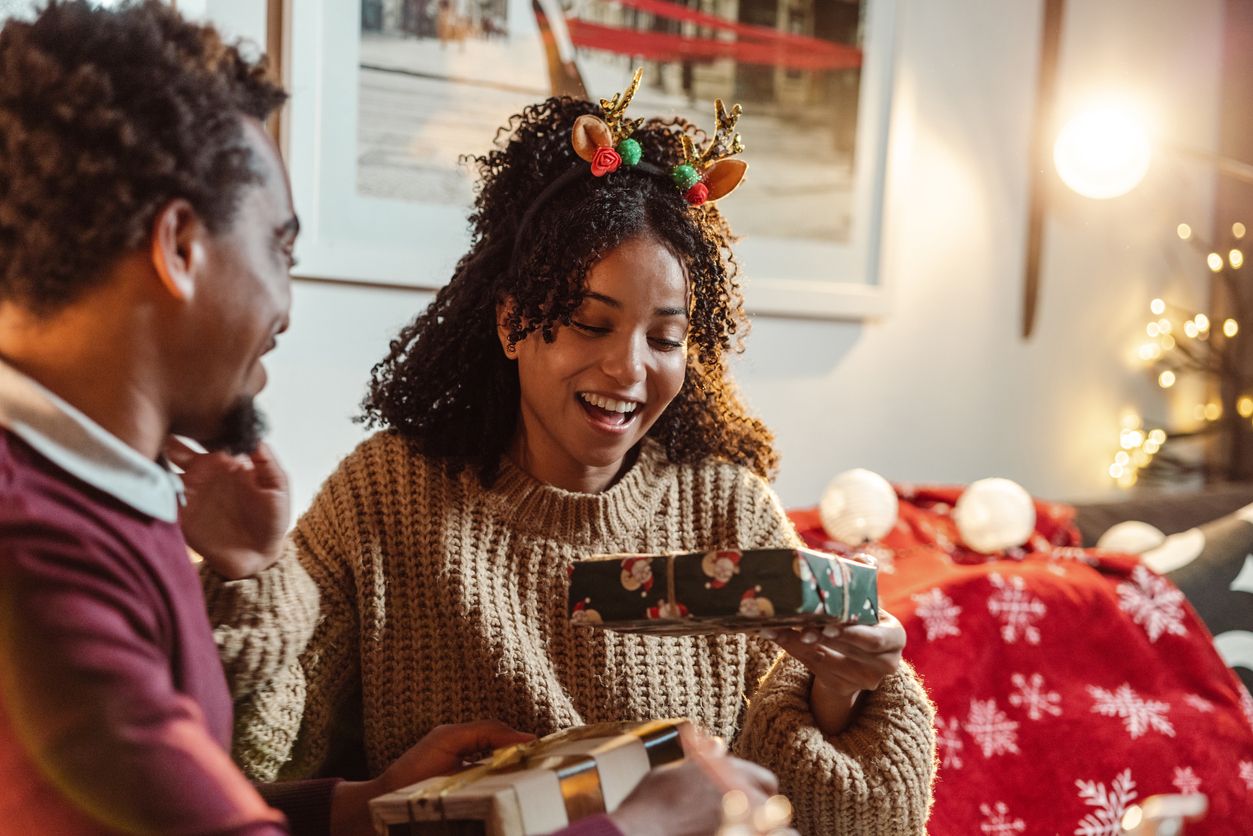 Happy young African-American couple enjoying at home during winter holidays