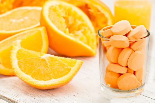 Sliced oranges and vitamin C tablets.