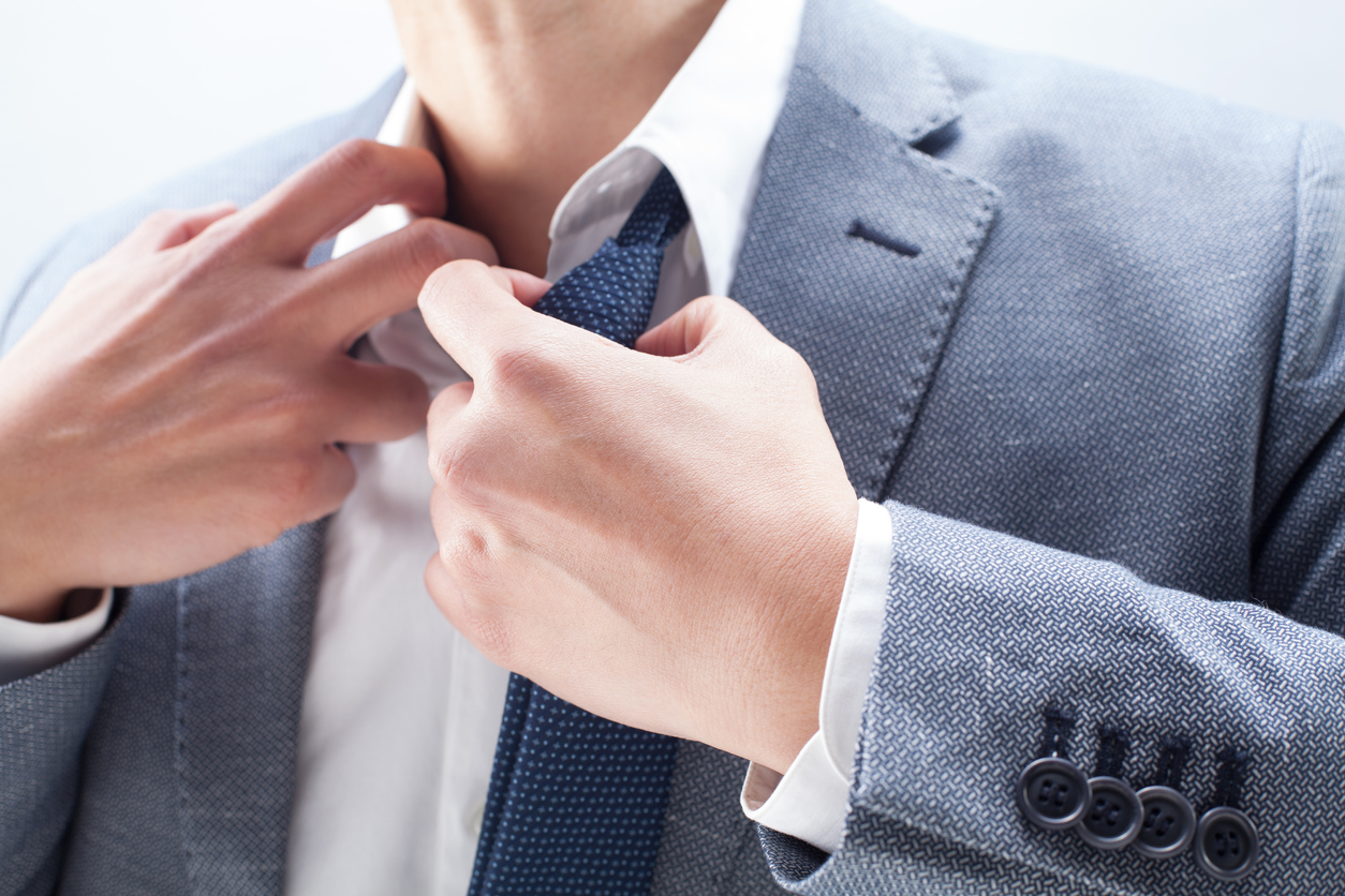 Man pulling at his collar and necktie. 
