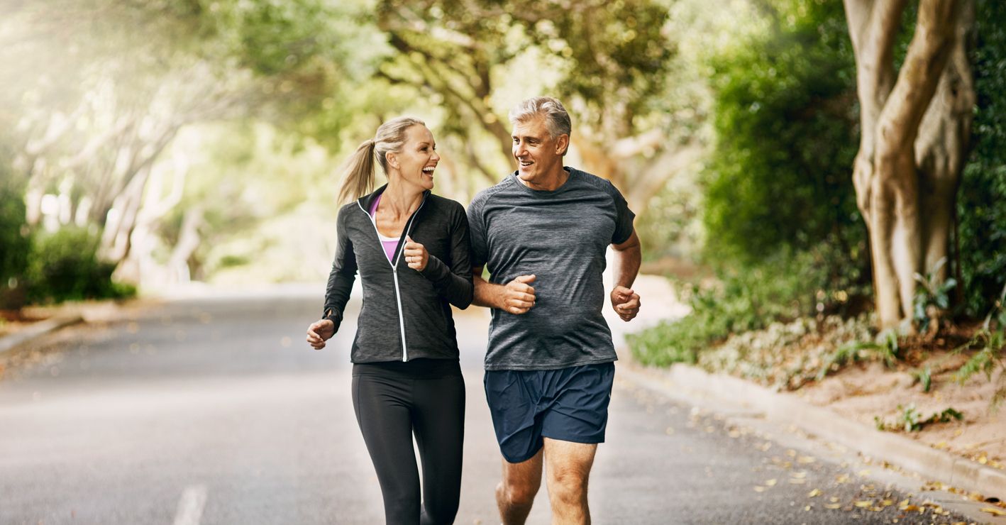 Mature adults jogging outdoors.