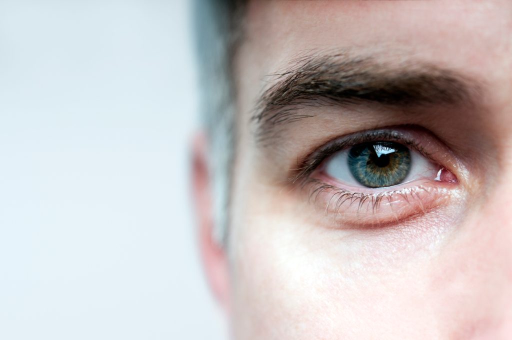 A closeup of a man's eye with salt and pepper hair