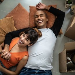 Happy young couple lying on the floor at new home