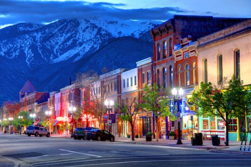 View of the historic main street in Ogden, Utah with large mountains in the background.