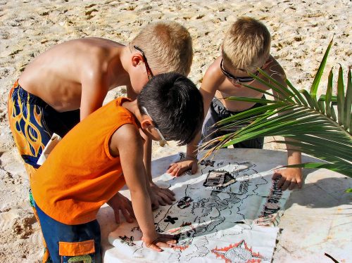 little boys at the beach embarking on a treasure hunt