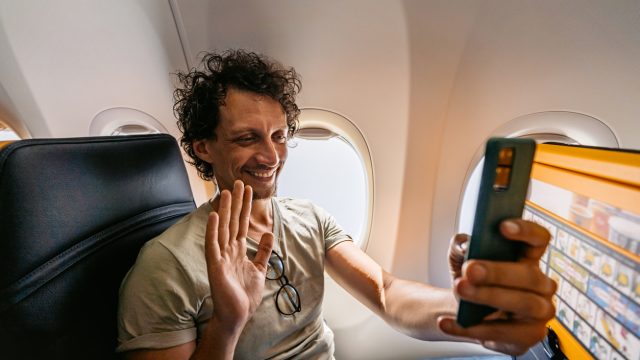A man making a video call while on an airplane