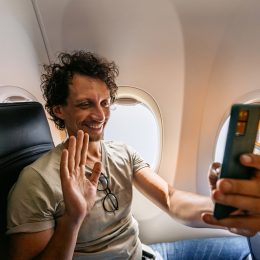 A man making a video call while on an airplane