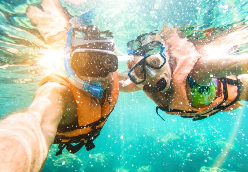 A couple goes scuba diving together.