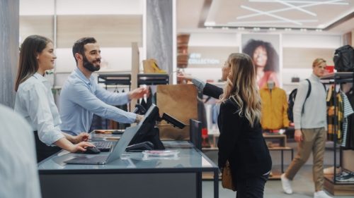 woman checking out with cashier at department store