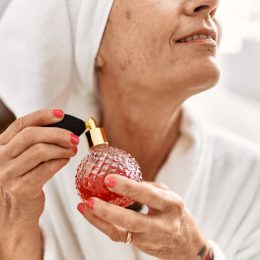 older woman spraying perfume