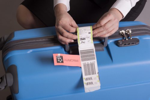 putting tag on checked luggage