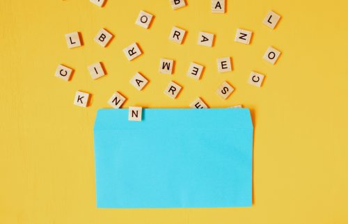 wooden letters pouring out of a blue envelope