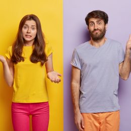man and woman shrugging their shoulders and looking confused