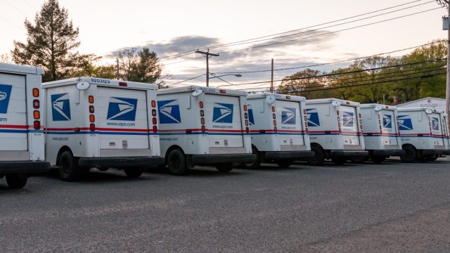 USPS mail vans parked outside of the post office