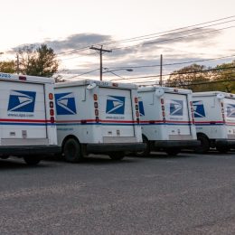 USPS mail vans parked outside of the post office