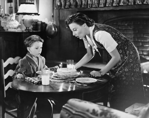 black-and-white still of a woman celebrating her son's birthday