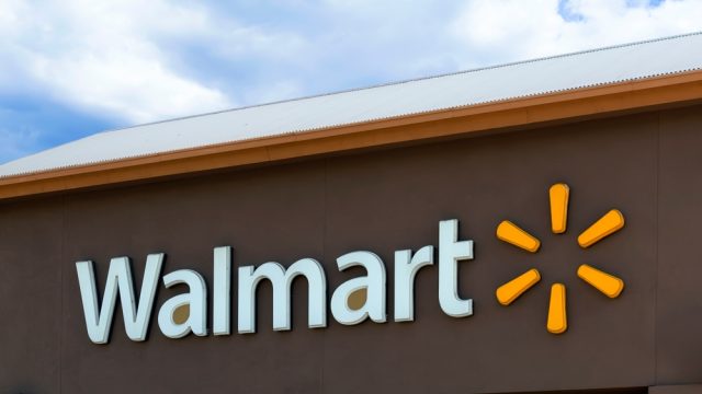 A Walmart sign from a storefront with a brown background