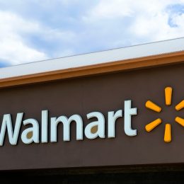A Walmart sign from a storefront with a brown background