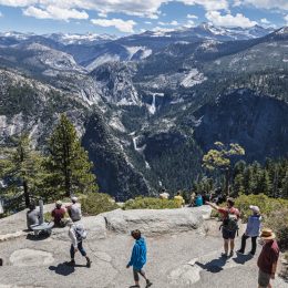 A group of tourists at Yosemite National Park looking over a viewpoint