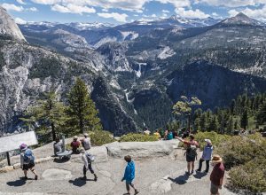 A group of tourists at Yosemite National Park looking over a viewpoint