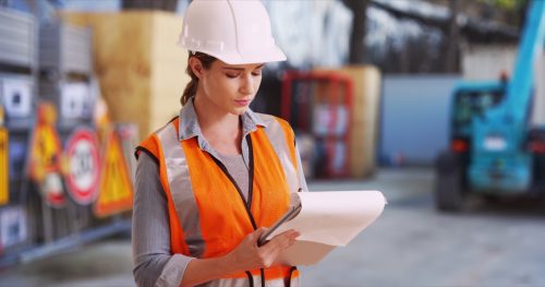 Female Construction Worker Checking Things off List