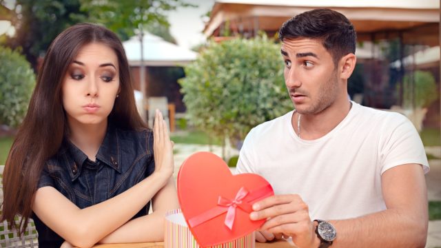 Woman refusing a gift from her boyfriend.