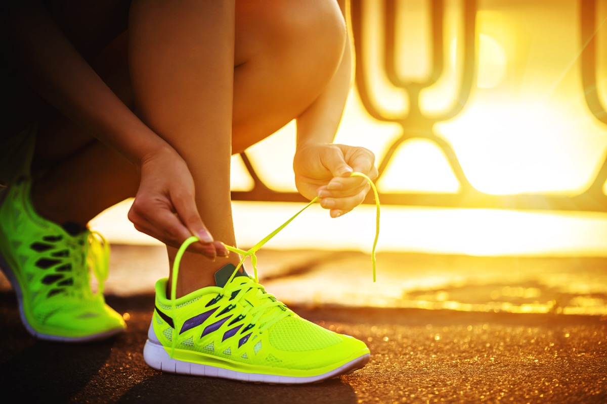 Female athlete tying laces for jogging