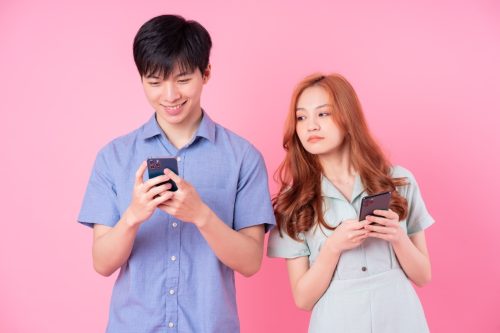 Young Asian Woman Looking at Her Friend's Phone