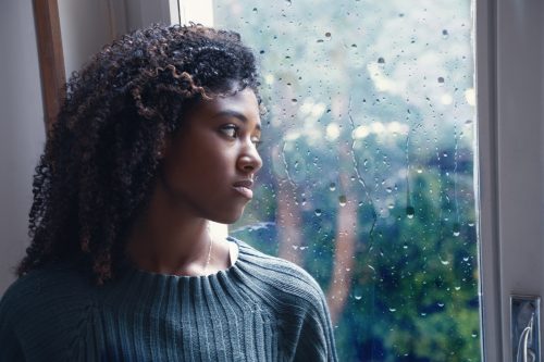 Woman looking out at the rain. 