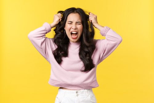 Woman shouting wanting to get revenge. Yellow background.
