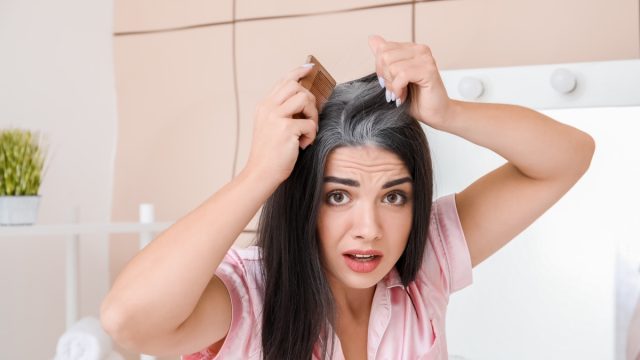 Woman coming her grey hair.