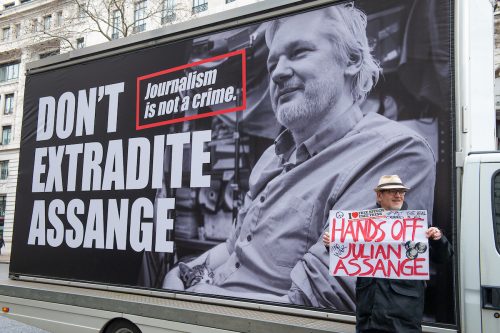A protester standing in front of a "Don't extradite Assange" sign in London in 2020