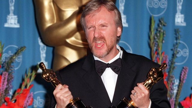 James Cameron holding two Oscars at the 1998 Academy Awards