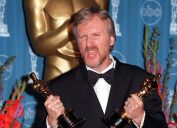James Cameron holding two Oscars at the 1998 Academy Awards