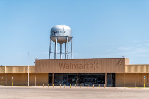 Rural Texas industrial city with old vintage dilapidated Walmart and water tank with sign