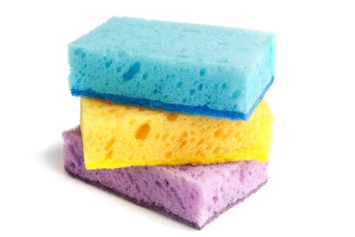 A stack of three colorful kitchen sponges, purple, yellow, and blue.