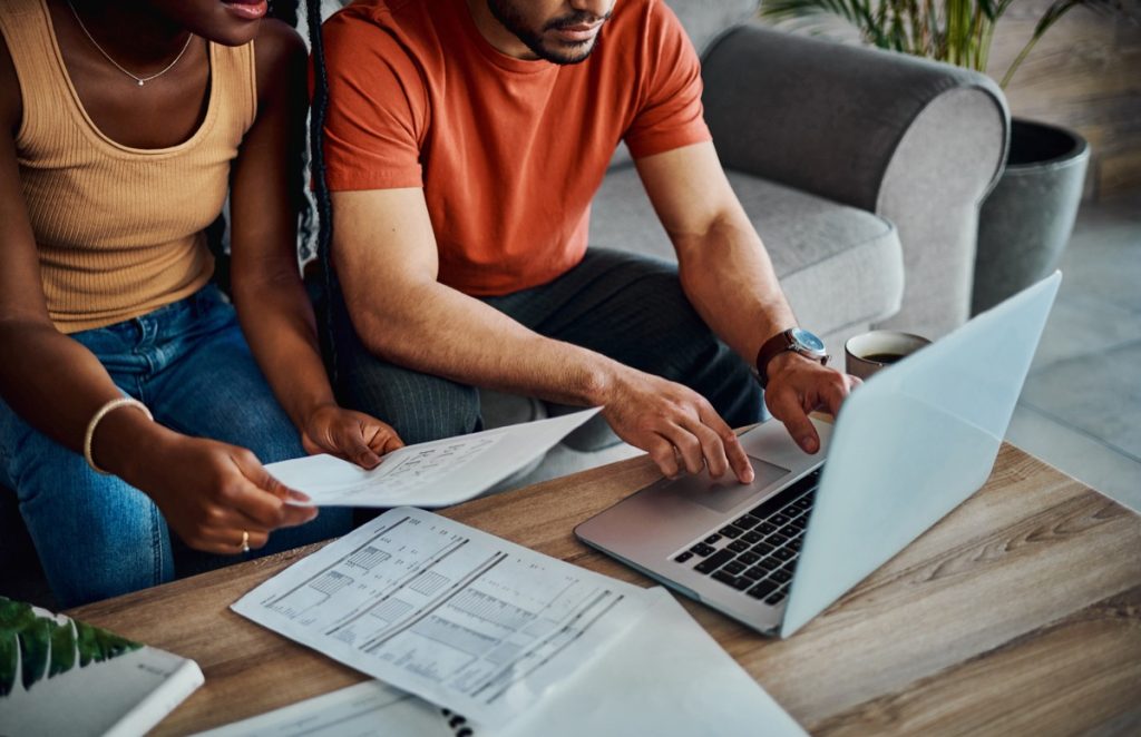 Man and woman working on taxes with laptop