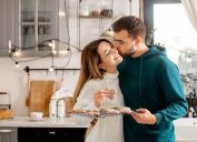 Young couple hugging while baking cookies in the kitchen