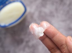 Close up of a hand using petroleum jelly
