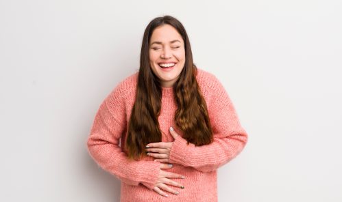 woman holding her belly laughing