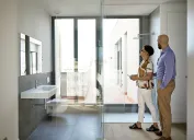 A couple of homebuyers looking at a modern bathroom in a house