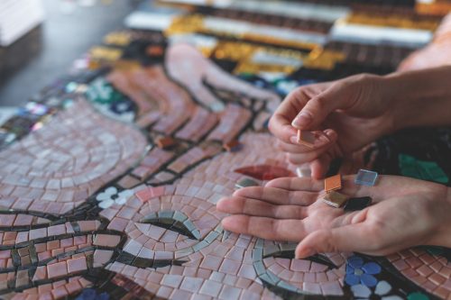 Female hands with mosaic tiles closeup