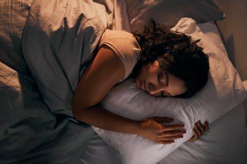 Woman having a good night of sleep in her bed.
