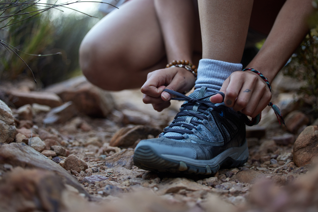 Person tying the laces on their hiking shoes.
