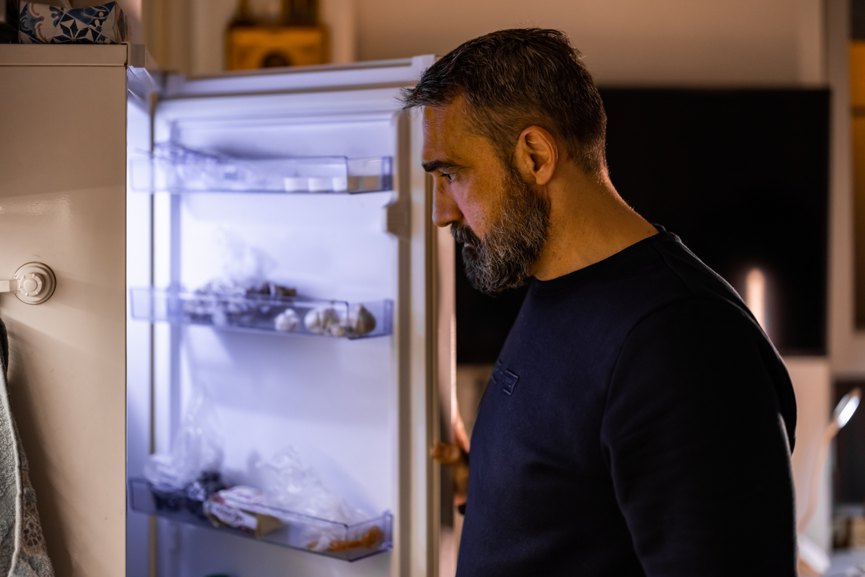 Man looking in refrigerator for a snack.