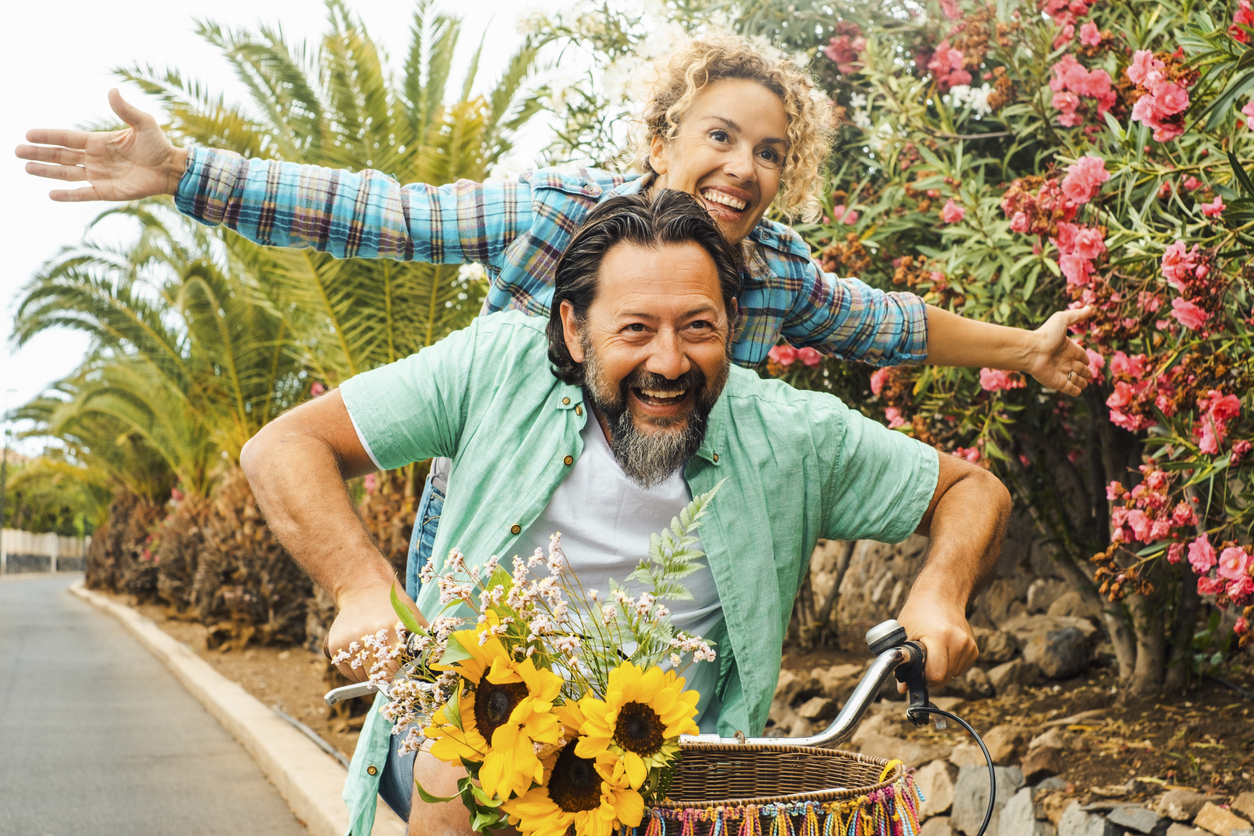young couple riding a bike together and laughing