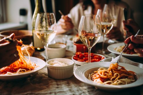 A close-up of a table at an Italian restaurant with pasta and wine.