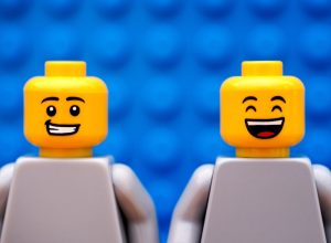 Two Lego minifigures - one with smirk and one happy