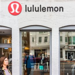 A Lululemon storefront with a customer exiting