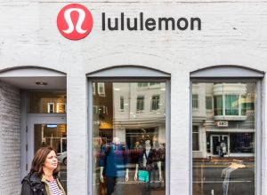 A Lululemon storefront with a customer exiting