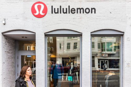 A Lululemon storefront with a customer exiting